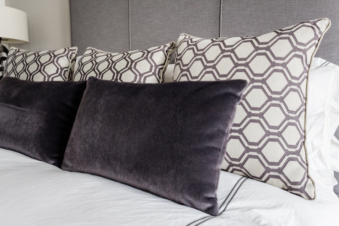 Velvet and patterned pillows on bed